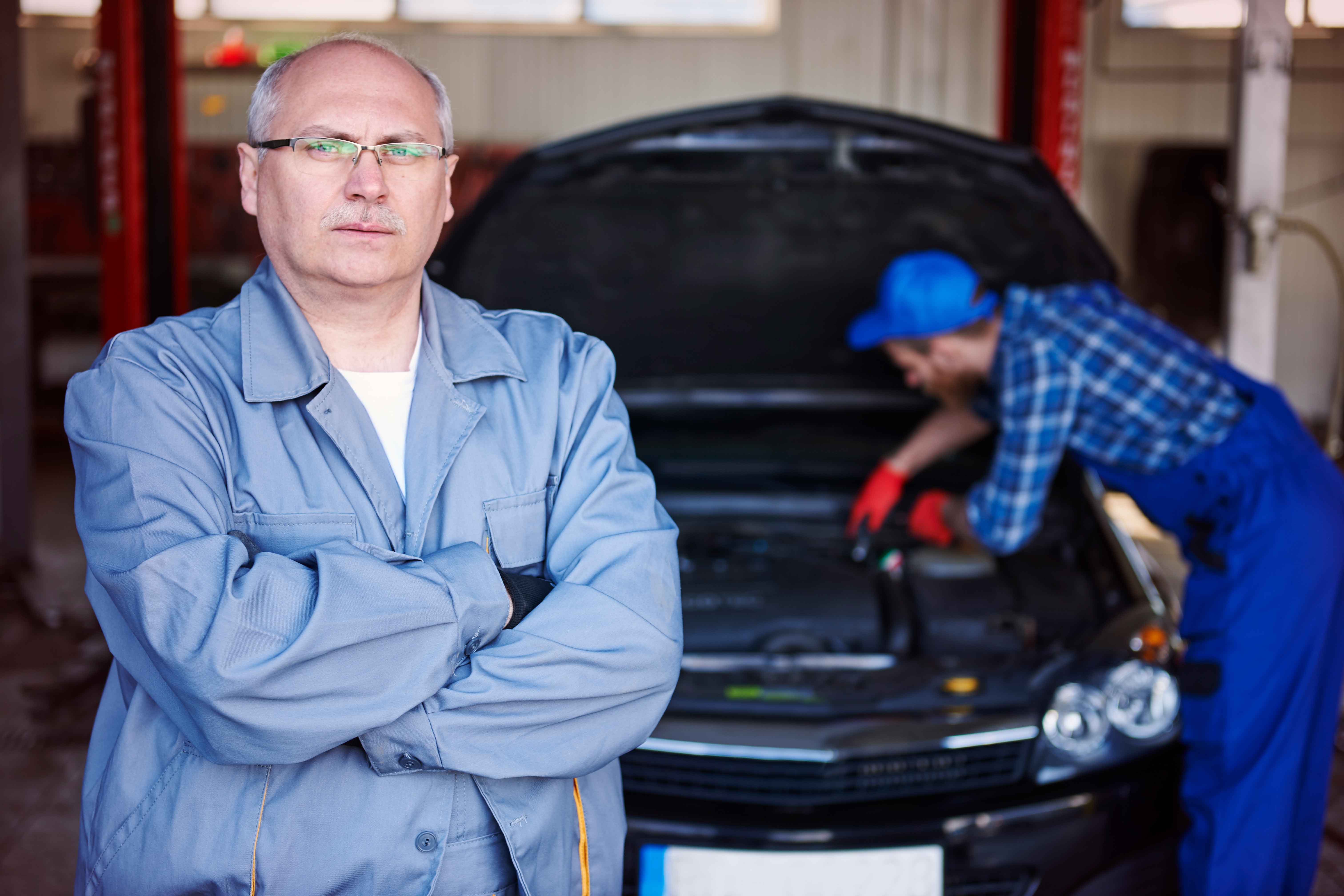 Marco DiRienzo posing in front of Enzo working on a vehicle